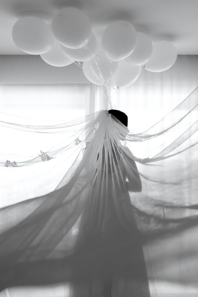 Marie posing in her wedding dress and some white balloons decoration | Esthesis Events