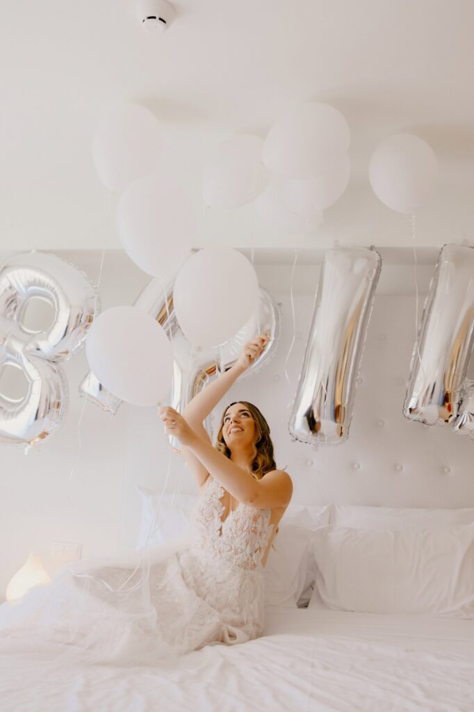 Marie posing in her wedding dress and some white balloons decoration | Esthesis Events