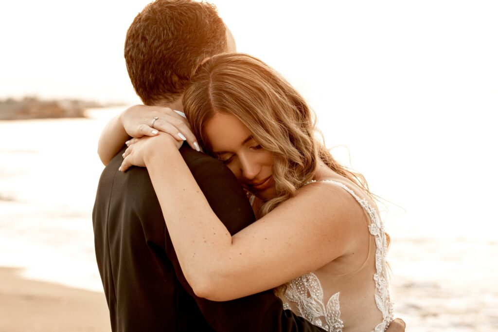 Marie lying in Theodore's arms on the beach | Esthesis Events