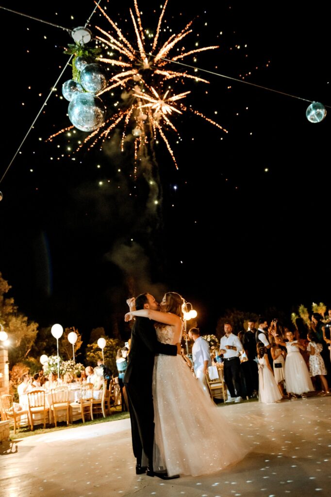 Theodore and Marie kissing at the wedding party with fireworks going off in the backround | Esthesis Events