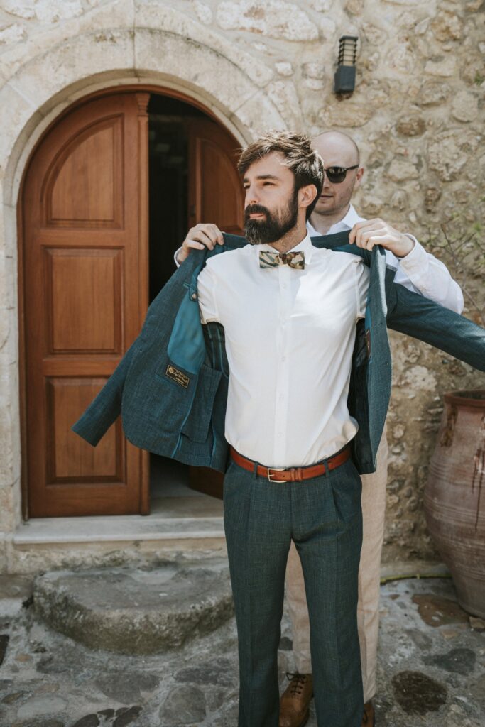 Michael getting ready as a groomsman helps him put on his jacket. | Esthesis Events Michael getting ready as a groomsman helps him put on his jacket. | Esthesis Events