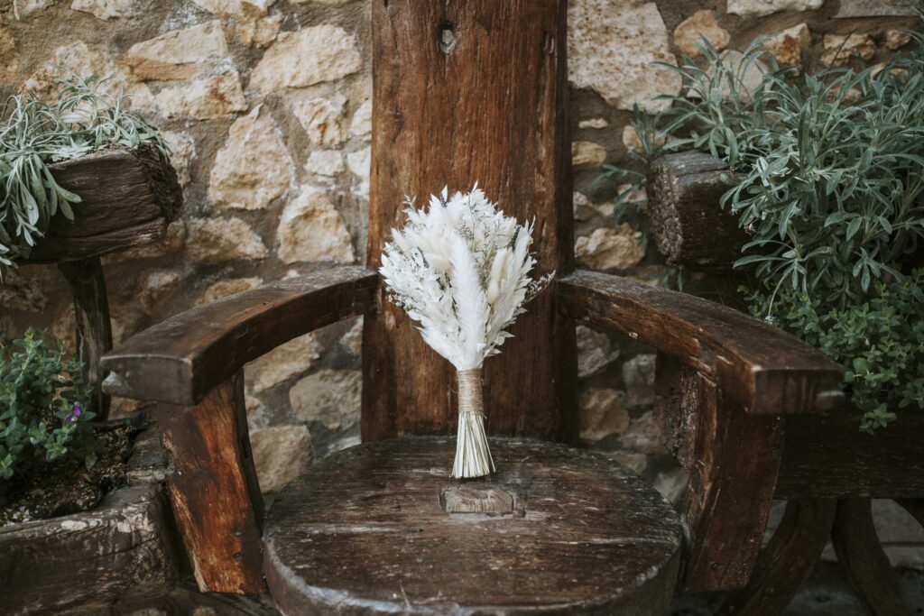 A close-up of the bridal bouquet placed on an antique wooden chair. | Esthesis Events A close-up of the bridal bouquet placed on an antique wooden chair. | Esthesis Events