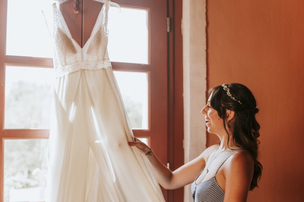 Jodie smiling as she marvels at her wedding dress. | Esthesis Events Jodie smiling as she marvels at her wedding dress. | Esthesis Events