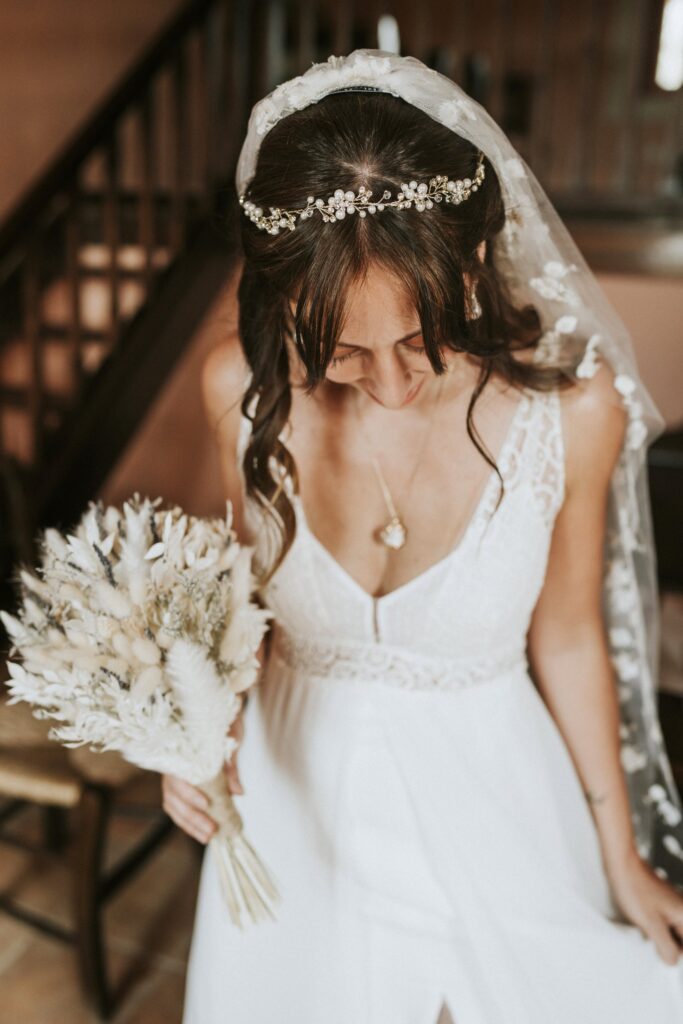 Jodie looking down to admire her wedding dress while holding her bridal bouquet. | Esthesis Events Jodie looking down to admire her wedding dress while holding her bridal bouquet. | Esthesis Events