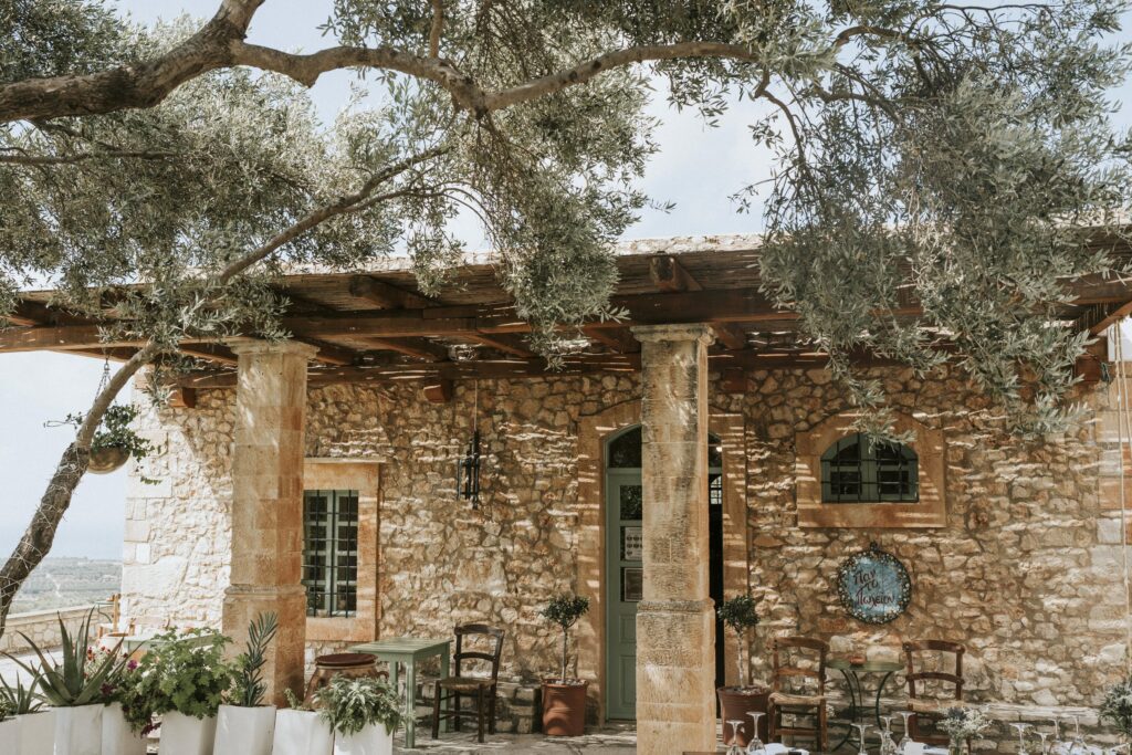 A traditional stone-built Cretan shop nestled among olive trees. | Esthesis Events A traditional stone-built Cretan shop nestled among olive trees. | Esthesis Events