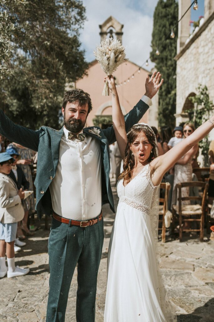 The bride and groom celebrating enthusiastically with arms raised as husband and wife. | Esthesis Events The bride and groom celebrating enthusiastically with arms raised as husband and wife. | Esthesis Events