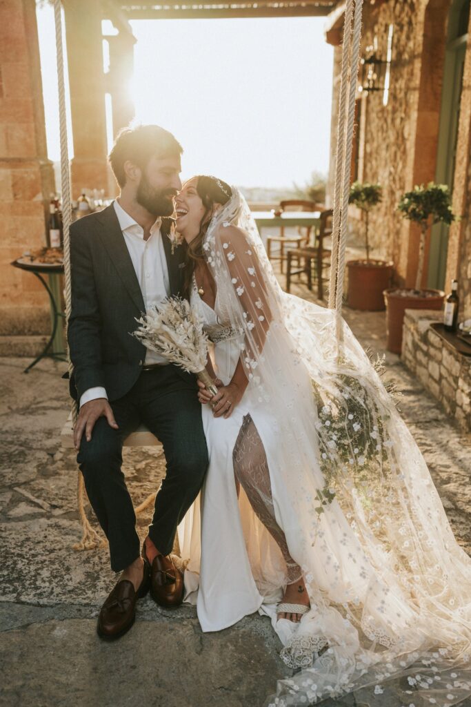 A charming wedding day portrait of the newlywed couple seated on a swing. | Esthesis Events A charming wedding day portrait of the newlywed couple seated on a swing. | Esthesis Events