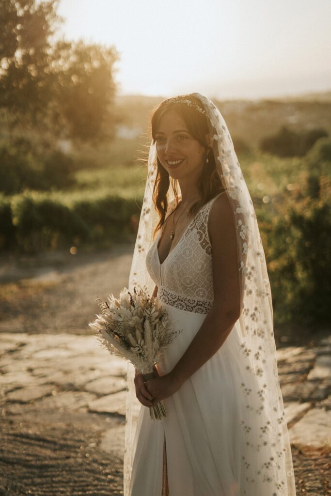 A graceful portrait of the bride, Jodie, holding her wedding bouquet during a golden sunset among the olive trees at Agreco Farm. | Esthesis Events A graceful portrait of the bride, Jodie, holding her wedding bouquet during a golden sunset among the olive trees at Agreco Farm. | Esthesis Events