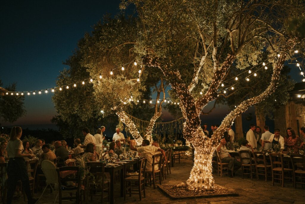 Wedding dinner setting under decorated olive tree. | Esthesis Events Wedding dinner setting under decorated olive tree. | Esthesis Events